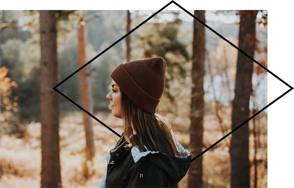 Young woman walking through the woods in the fall